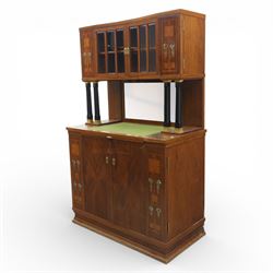 Continental Art Nouveau cocktail cabinet, the stepped cornice over a glazed upper section with panelled doors, enclosing fitted shelf, the central section with mirrored back and green baize serving surface flanked by ebonised and gilt detailed pilasters, the base fitted with cupboard doors inlaid with stylised foliate and geometric motifs, on a plinth base