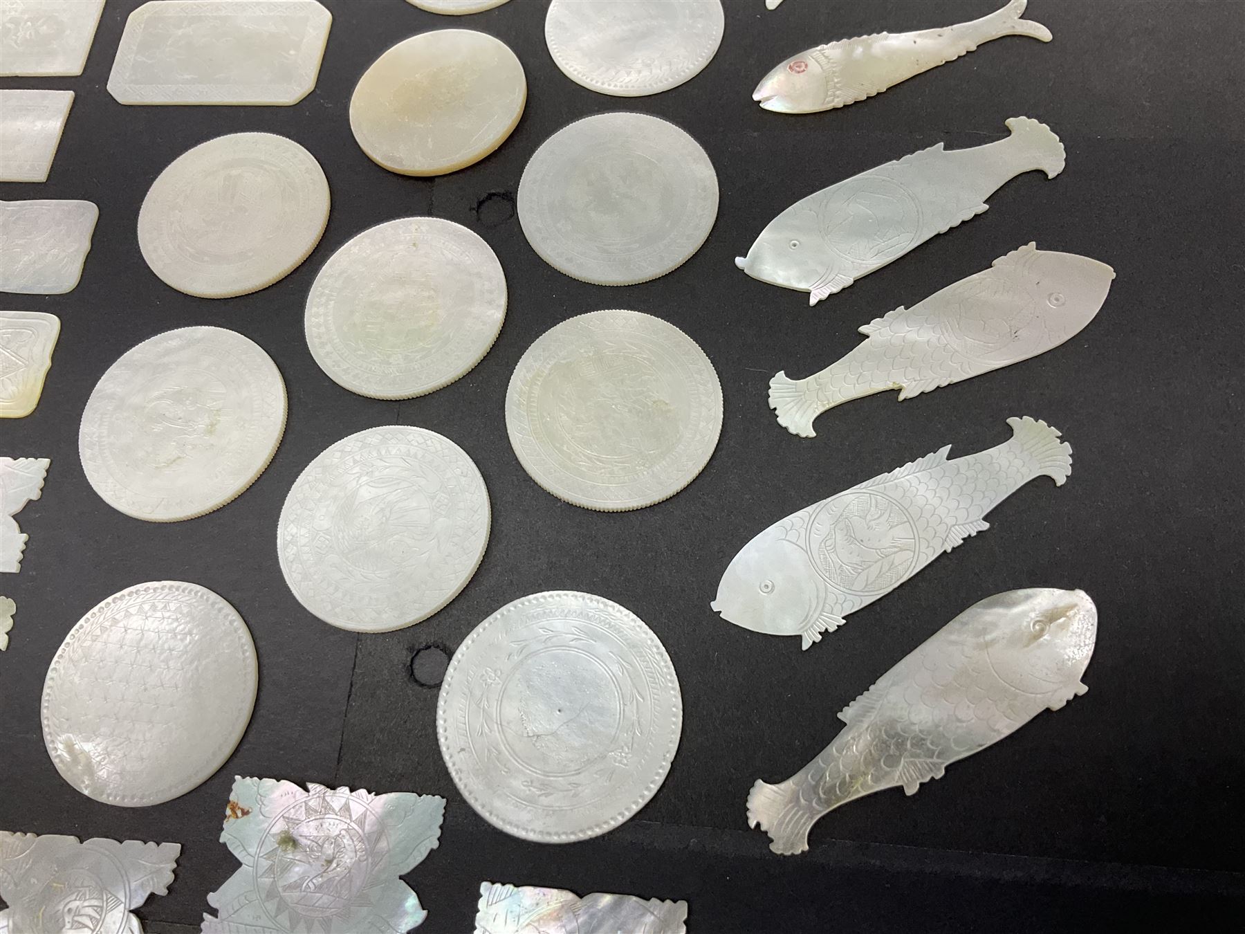 Collection of fifty seven Chinese mother of pearl gaming counters or tokens, of various size and form including rectangular, circular and fish shaped examples, various decoration including floral motifs, largest rectangular examples L6cm