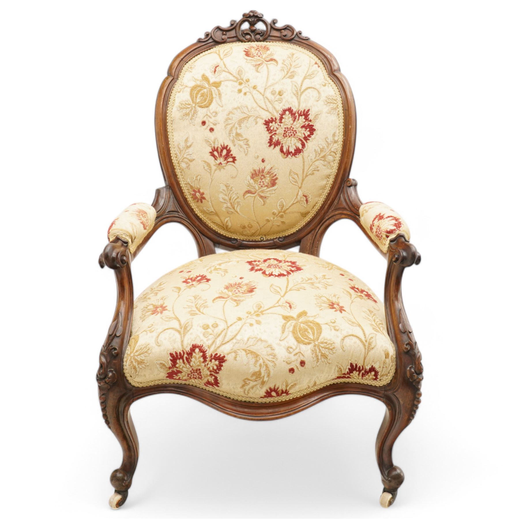 Victorian Ladies and Gentleman's carved walnut drawing room chairs, each with shaped cresting rail carved with scrolls and flowerheads, upholstered in pale gold floral fabric, raised on foliate-carved cabriole supports terminating to brass and ceramic castors
