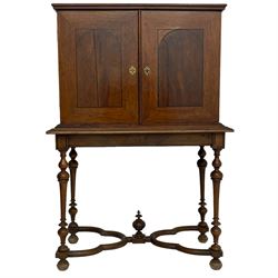 19th century walnut collector's cabinet on stand, the moulded top over two figured doors with arched ebony stringing, the interior fitted with various drawers and central cupboard, the figured drawer fronts with moulded ebonised borders and foliage cast gilt metal loop handles,  the stand with moulded top rails over turned supports, cusped lower rails with central finial, on turned feet