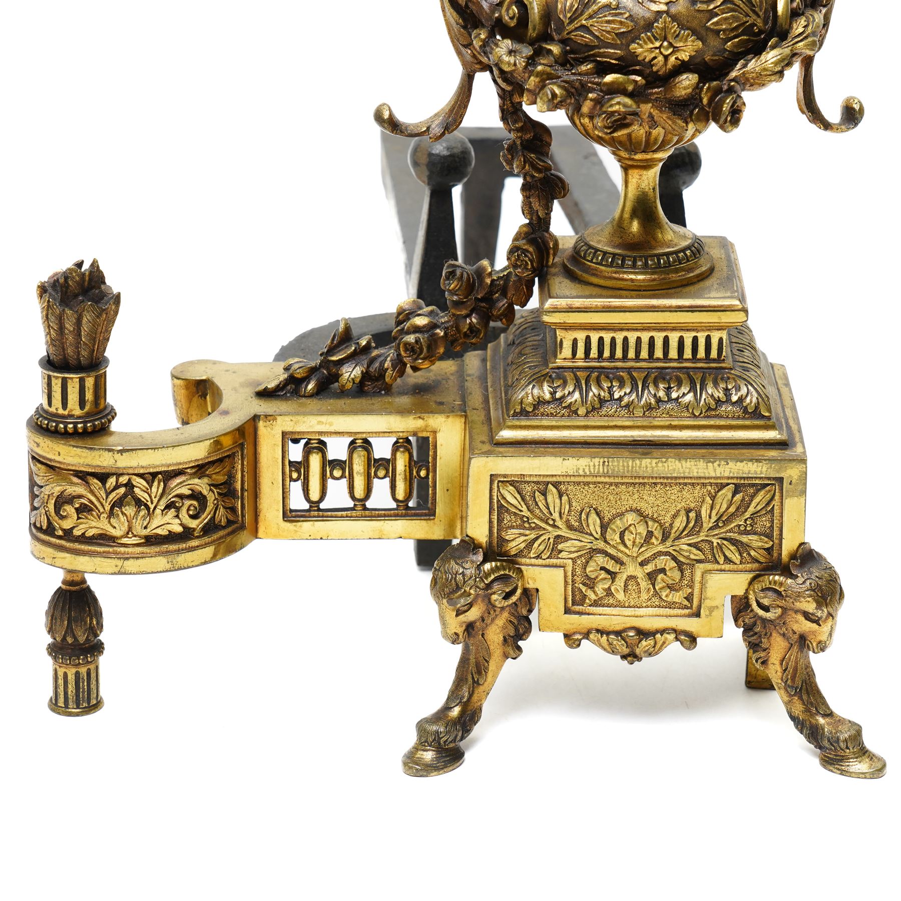 Pair of gilt metal fire dogs, formed as an urn with classical decoration, including putti and floral swags, raised on a square stepped base, the feet formed as rams heads and hoofs, H45cm x W28cm