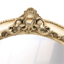 Early 20th century cream and parcel-gilt oval wall mirror with mer-putti pediment