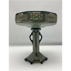 Early 20th Century Eichwald table centrepiece in the secessionist style, the bowl of decagon form decorated with pink and green floral geometric motifs upon blue grey ground raised upon central column with twin handles and spreading shaped foot, with impressed marks beneath, H26cm