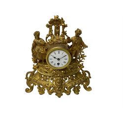 French - late 19th century French  8-day spelter mantle clock, with rococo decoration and a drum timepiece movement flanked by two standing figures in 18th century costume, enamel dial with Roman numerals, minute track and spade hands. With pendulum. 