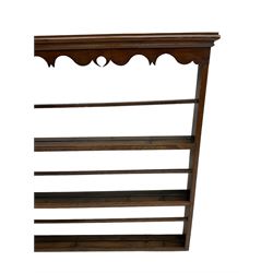 20th century oak wall hanging plate rack, shaped fretwork frieze over three tiers