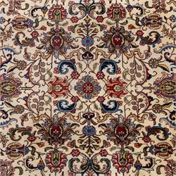 North West Persian Tabriz, hand-knotted carpet, ivory ground with dense scrolling vine-work, palmettes, flowering sprays, and stylized leaves framed by a principal border of scrolling floral motifs and palmettes and flanked by narrow guard borders, with cotton fringe ends