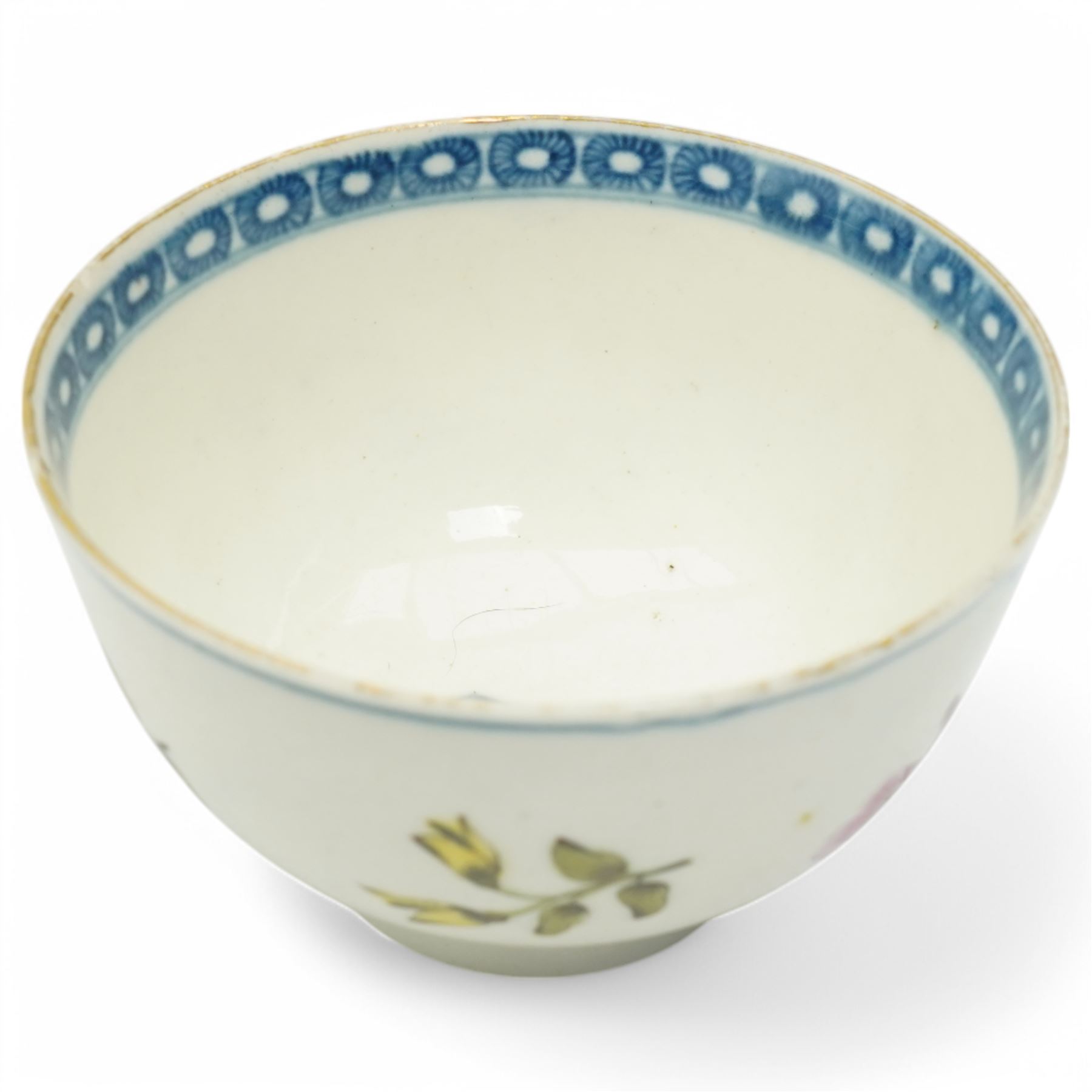 Worcester tea bowl and saucer, c.1770, painted with polychromatic floral sprays within blue borders, bearing crescent marks to base, with another similar early example, unmarked