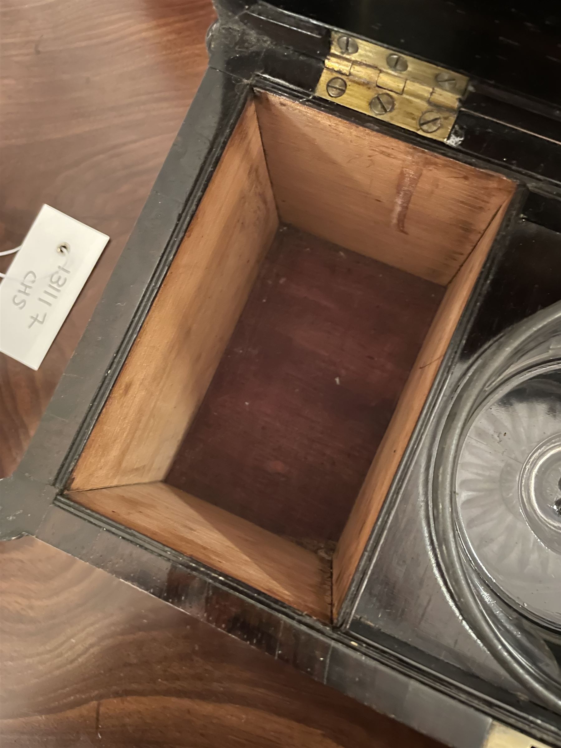 Early 19th century rosewood and brass inlaid tea caddy, of sarcophagus form, the front and hinged opening cover inlaid with brass scrolling panels, opening to reveal a compartmented interior with twin removable boxes with conforming inlaid brass detail to the hinged covers and zinc lining to the interiors, flanking a later glass mixing bowl, the whole upon four turned cylindrical feet, H21cm W36cm D20cm