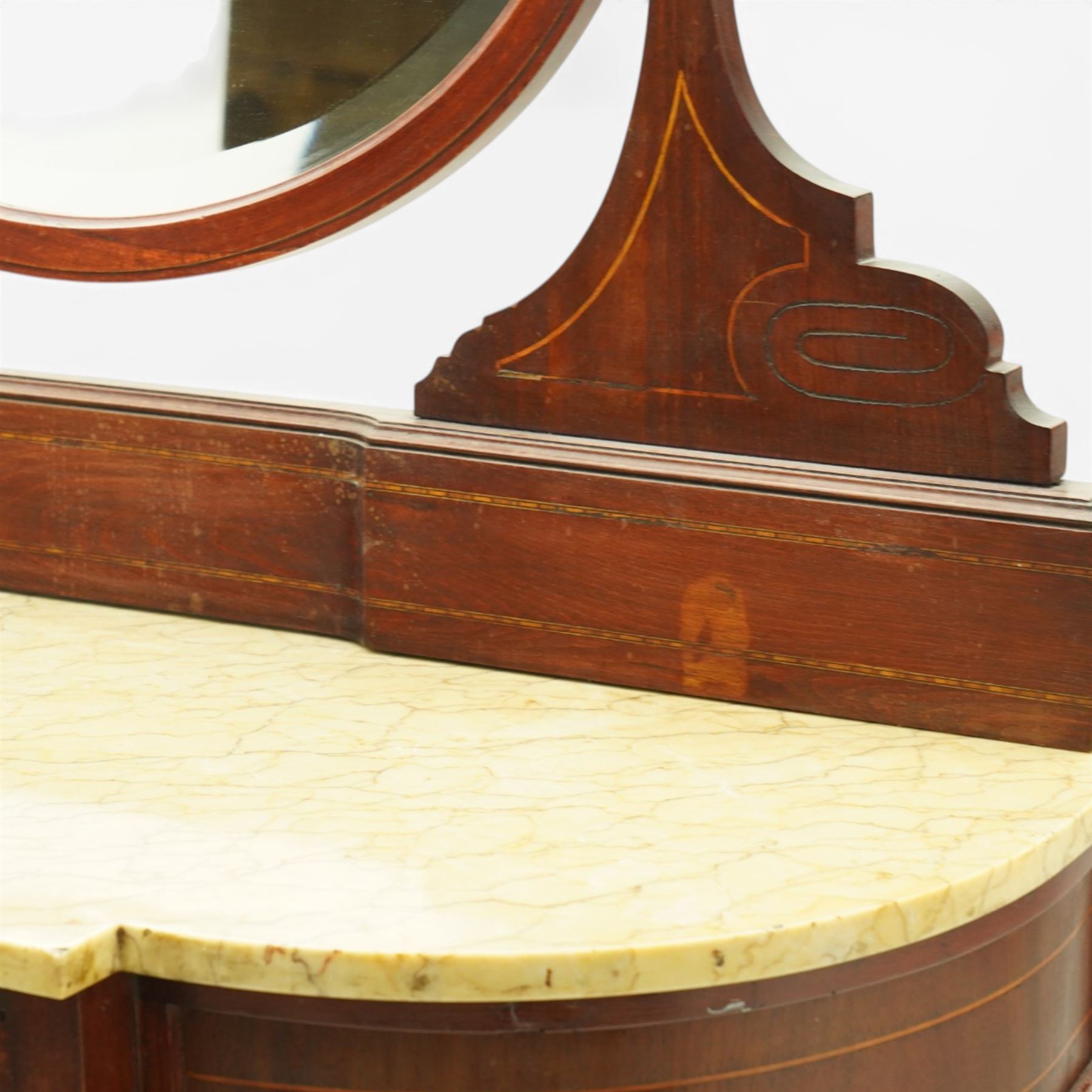 Edwardian inlaid mahogany dressing table, serpentine fronted marble top over central frieze drawer flanked by bowed sides, raised back with line inlaid decoration and oval swing mirror, on slender tapering supports united by shaped undertier