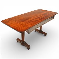 William IV mahogany sofa table, the rectangular top with rounded corners and hinged drop leaves to either end, above a shallow frieze fitted with two drawers opposing conforming dummy drawers, supported on octagonal tapering legs with ring turnings, joined by a shaped stretcher and raised on platform bases with scroll feet