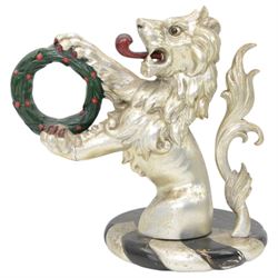 20th century carved silvered wood crest of a lion holding a wreath, possibly a horse tether, on circular wooden plinth, H37cm 