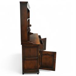 Contemporary georgian style oak dresser, open rack top with two shaped shelves and small side drawers, base with rectangular top over two drawers with brass swing handles, twin arched panelled doors below, on bracket feet