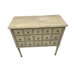 Washed finish pigeon hole or apothecary style chest, fitted with fifteen drawers, raised on fluted tapered supports 