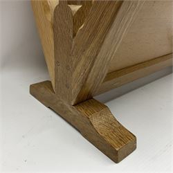 Mouseman - oak magazine rack, the top rail pierced with handle and carved with mouse signature, octagonal supports with two panelled and splayed sides, on sledge feet, by the workshop of Robert Thompson, Kilburn 