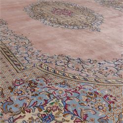 South East Persian Kirman hand-knotted rug, pale blush field with central scalloped medallion within an elaborate scalloped cartouche, spandrels filled with fine scrolling vine-work, palmettes and floral sprays, enclosed by wide and narrow borders in soft tones of blush pink, ivory, powder blue, sage green and pale gold, with cotton fringe ends 