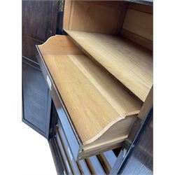 Early 20th century oak triple wardrobe, three panelled doors with geometric mouldings and fretwork spandrels, the interior fitted with slides and hanging rail