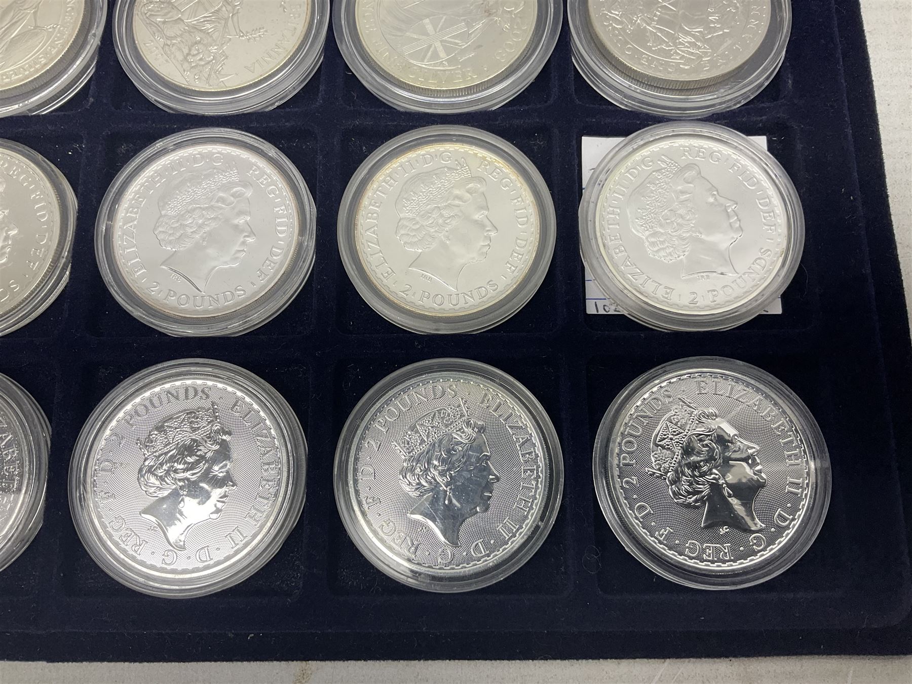 Twenty-four Queen Elizabeth II Britannia one ounce fine silver two pound coins, dated 1998, 1999, 2000, 2001, 2002, 2003, 2004, 2005, 2006, 2007, 2008, 2009, 2010, 2011, 2012, 2013, two 2014, 2015, 2016, 2017, 2018, 2019 and 2020 (24), housed on a coin tray