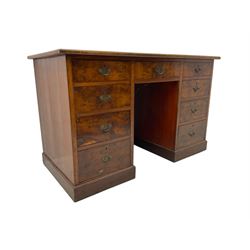 Late 19th to early 20th century walnut pedestal desk, rectangular top inset with red tooled leather writing surface, over a central frieze drawer flanked by two pedestals, each fitted with four graduated drawers with brass escutcheons and drop handles, the whole raised on a plinth base