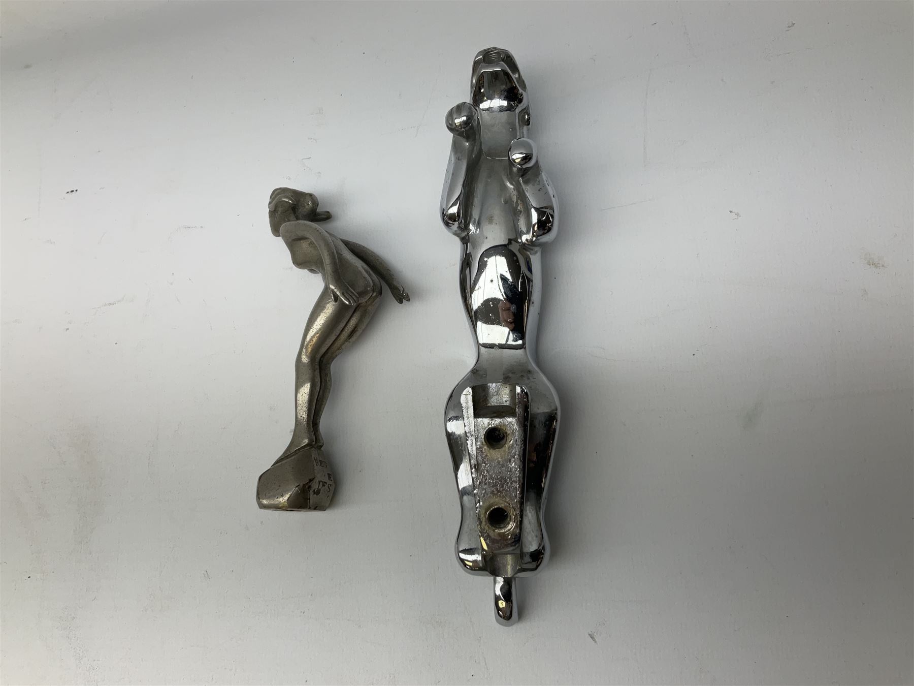 Nickel plated car mascot as a nude lady in a diving pose, similar to an A.E. Lejeune 'Speed Nymph', but marked 'N.L.C. Co. RegEd Des.'; chrome leaping Jaguar car mascot; and quantity of car model name letters, numbers and logos including Mercedes-Benz etc