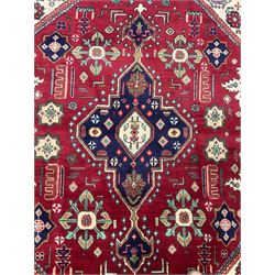 Qashqai red and blue ground rug, with central medallion, green repeating border with geometric motifs 