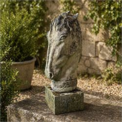 Large weathered cast stone horse head figure, raised on square plinth