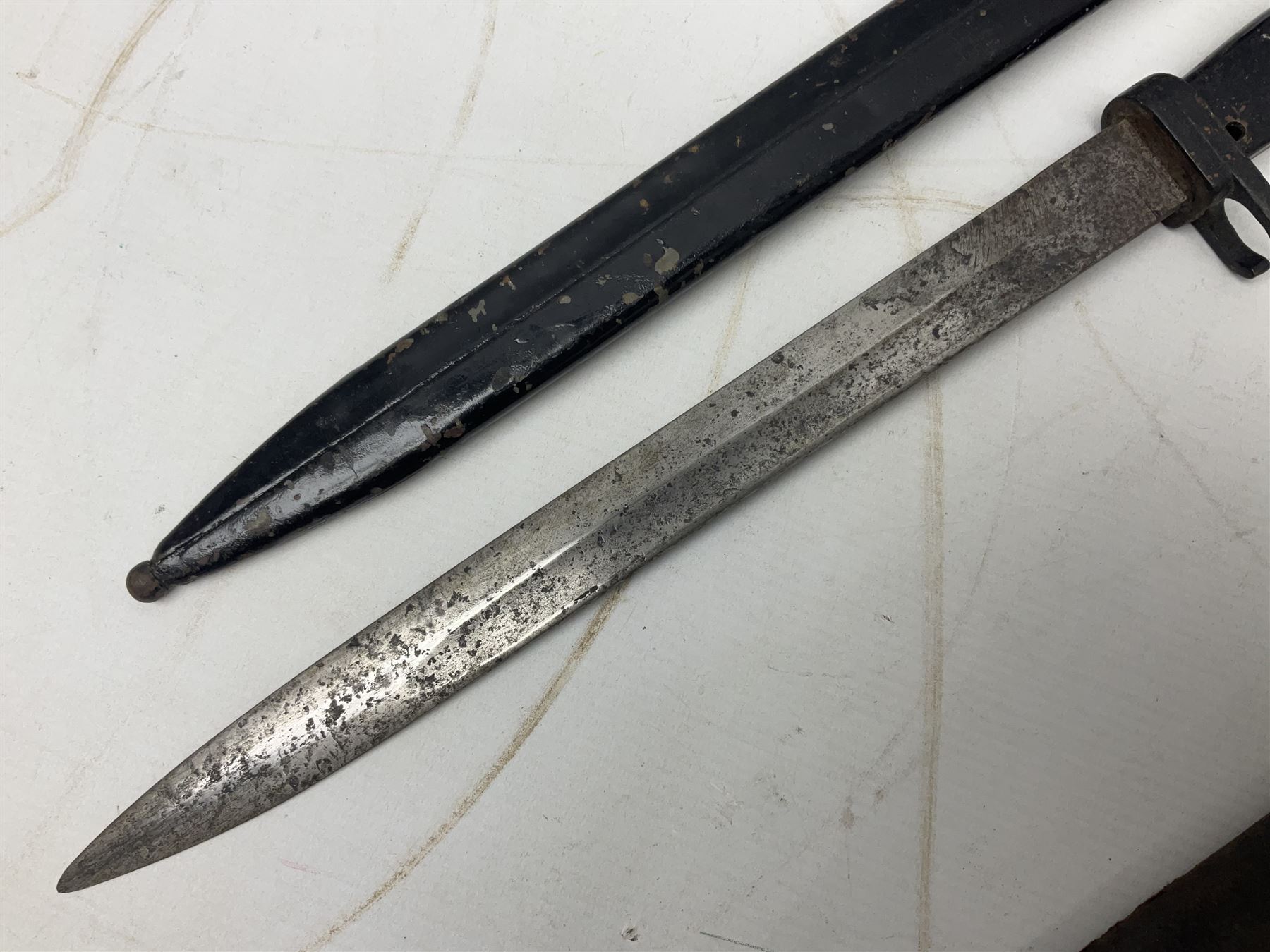 British No 7 MKI knife bayonet with 20cm single edged fullered clipped point blade;  blackened steel, large muzzle ring cross-guard; blackened swivelling pommel marked 'F5H'; red Tufnol composite grips; in blackened steel scabbard L33cm overall; British Pattern 1888 bayonet with scabbard; and German Ersatz bayonet with scabbard (3)