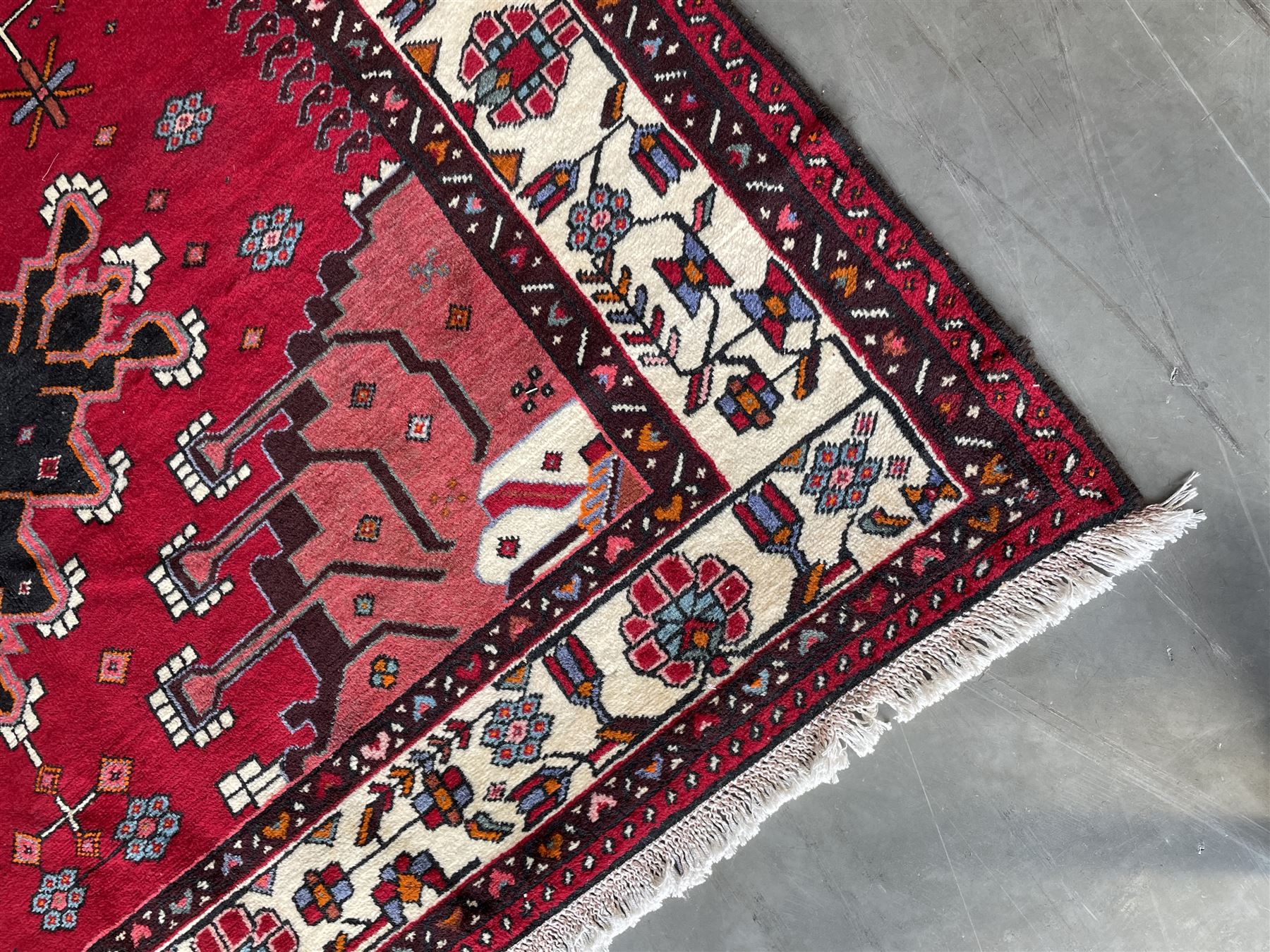 Persian Hamandan rug, the red ground field decorated with triple medallions and stylised motifs