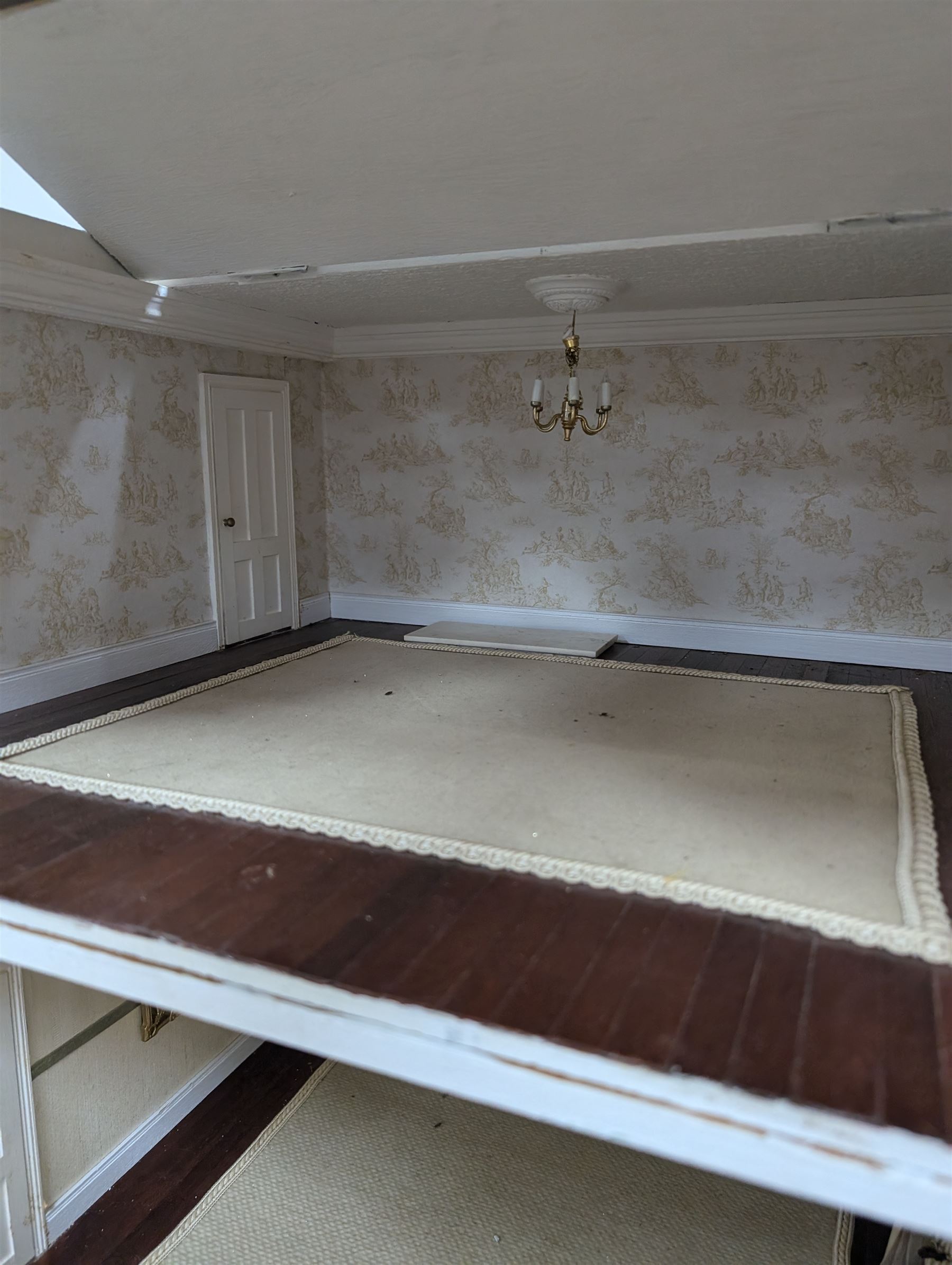 Two modern three storey dolls houses, each painted green with decorated interiors, both upon a single white wooden base, together with a large collection of dolls house furniture, accessories and figures 