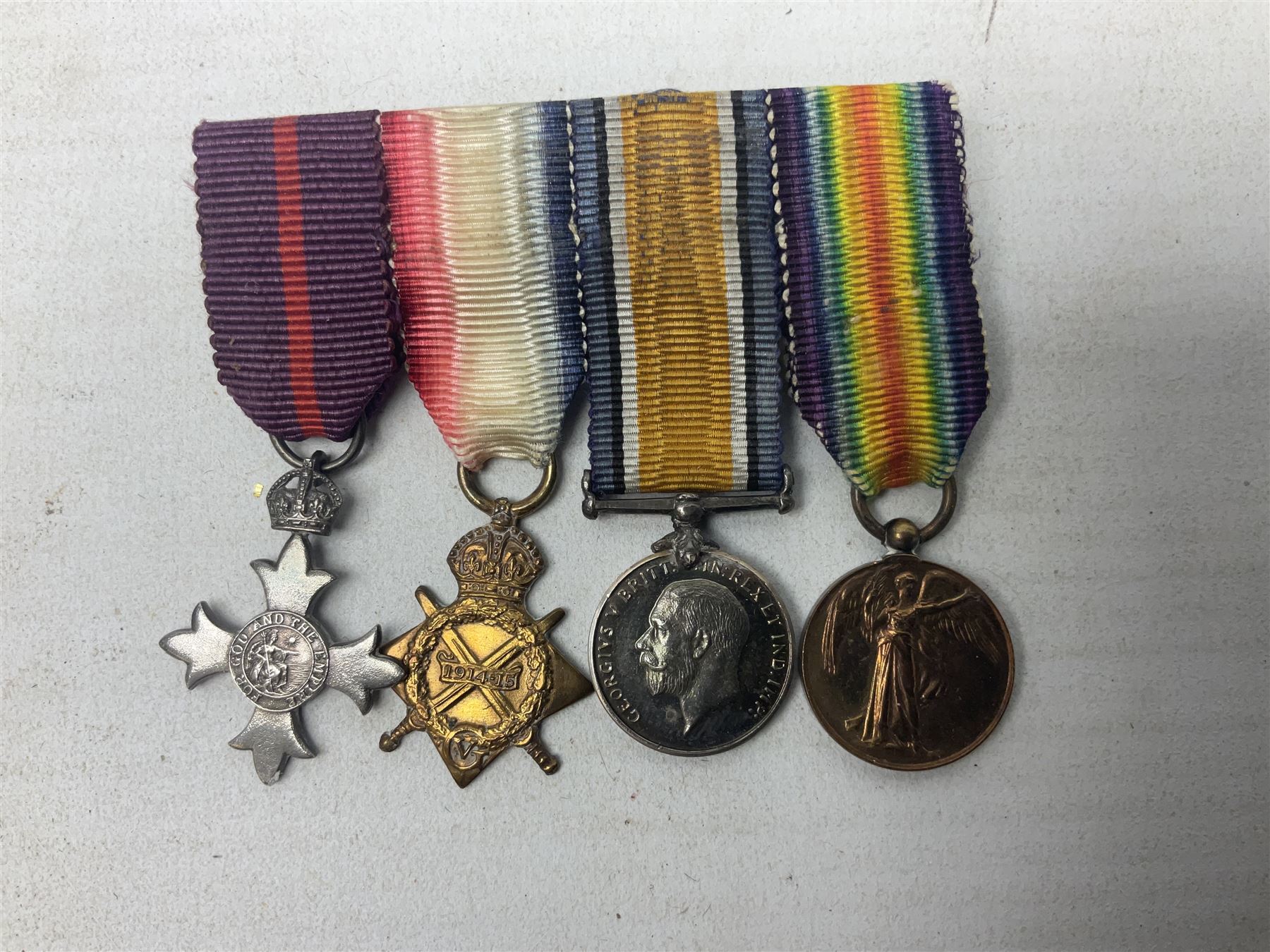 George V Military Cross miniature group of six medals comprising MC, WW1 trio including 1914 Star, Long Service and Good Conduct Medal and General Service Medal with Iraq clasp; and miniature group of four medals comprising Military OBE and WW1 trio including 1914-15 star; all with ribbons and both on pinned wearing bars