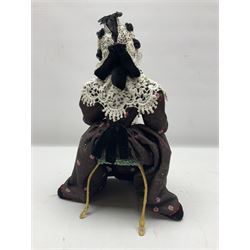 Anna Meszaros Hungary - hand made needlework figurine 'Old Lady' seated on a stool wearing a lace trimmed black/white/red floral full length dress and hat, working on a piece of lace H30cm  Auctioneer's Note: Anna Meszaros came to England from her native Hungary in 1959 to marry an English businessman she met while demonstrating her art at the 1958 Brussels Exhibition. Shortly before she left for England she was awarded the title of Folk Artist Master by the Hungarian Government. Anna was a gifted painter of mainly portraits and sculptress before starting to make her figurines which are completely hand made and unique, each with a character and expression of its own. The hands, feet and face are sculptured by layering the material and pulling the features into place with needle and thread. She died in Hull in 1998.