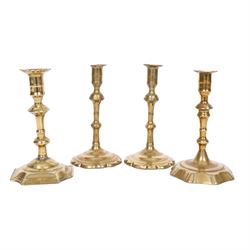 pair of 18th century brass candlesticks, each having slender knopped stems and scalloped p...
