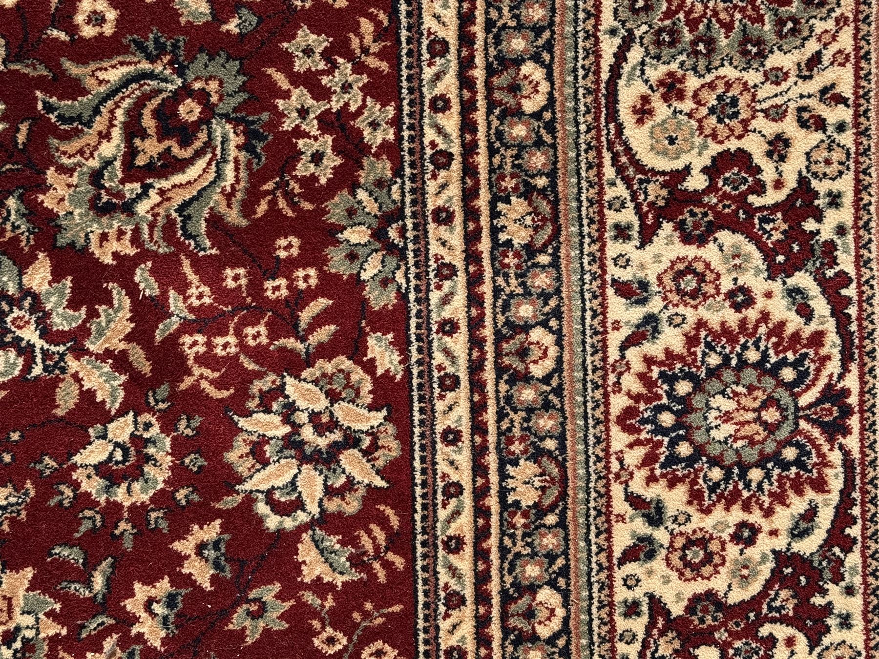 Royal Kashmir worsted wool modern Persian design area rug, with crimson field and stylised rosette patterning throughout, surrounded by wide multi-band border incorporating cartouche and lotus flower motifs