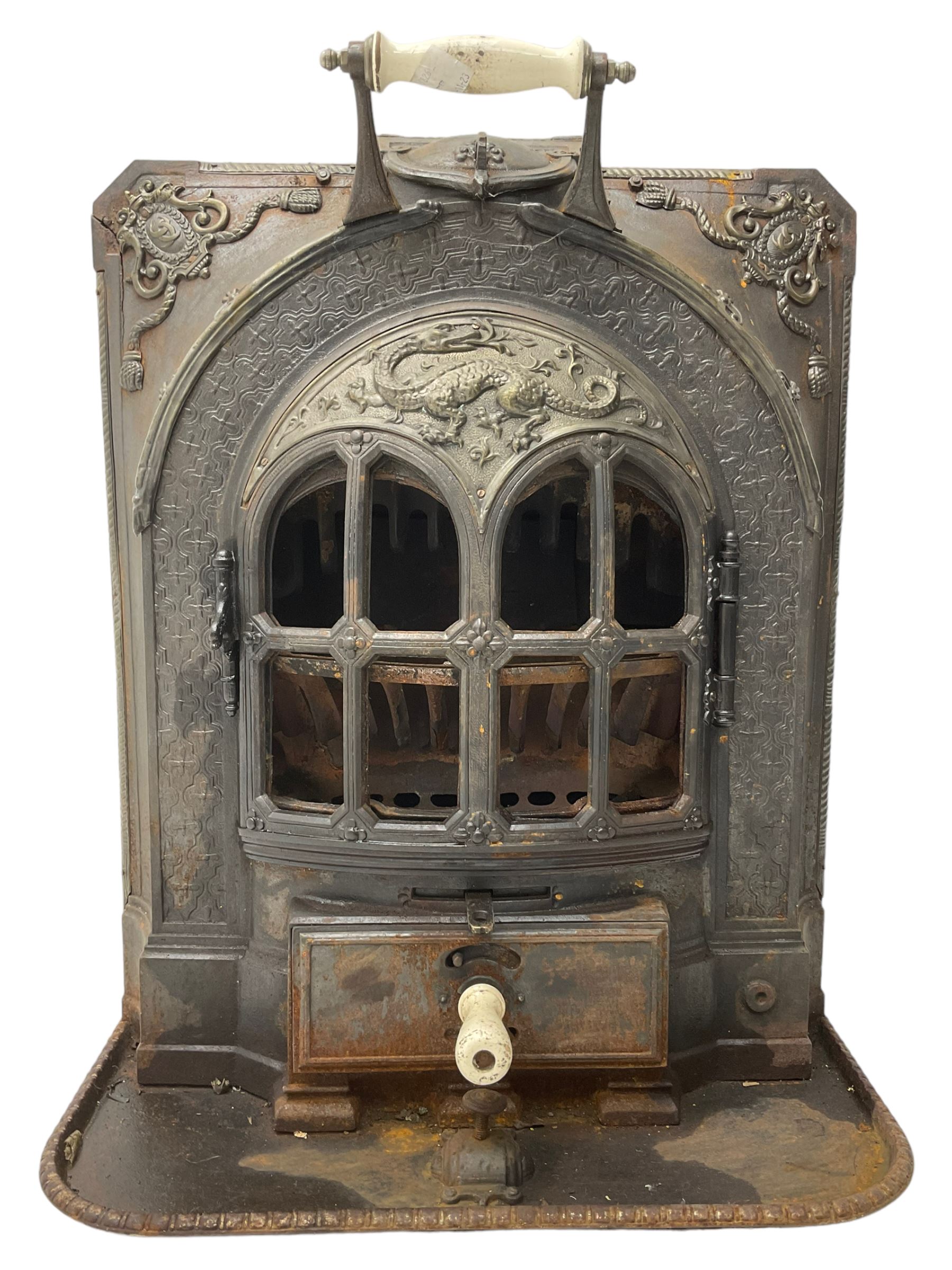 La Salamandre - early 20th century cast iron wood burning stove, decorated with salamander and cartouche motifs, fitted with porcelain handle, on rear castors 