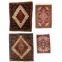 Small Hamadan dark indigo ground rug, central ivory and maroon lozenge with geometric decoration, guarded border with repeating stylised plant motifs, together with three others (4)