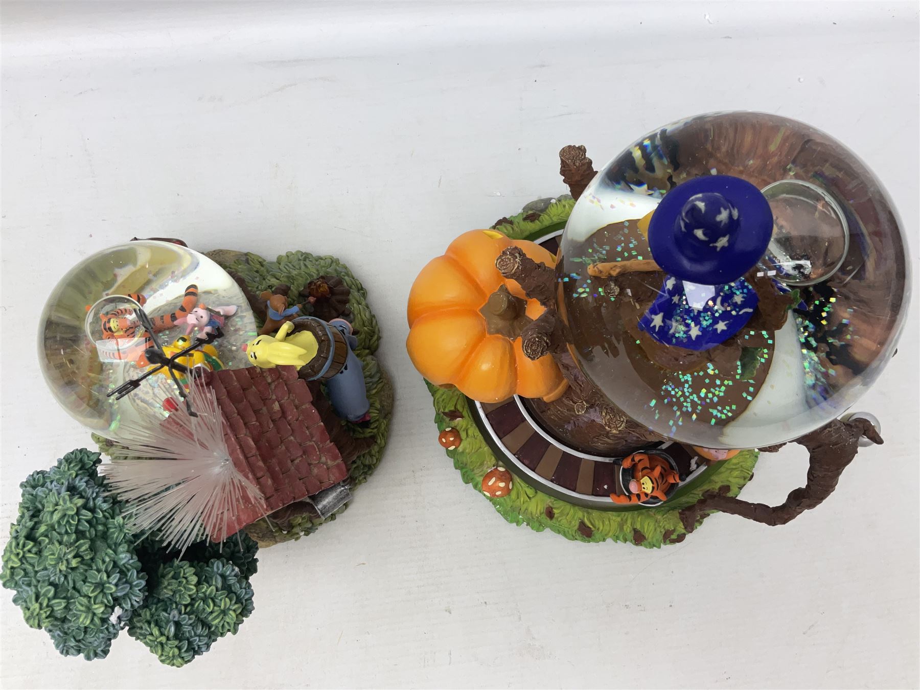 Six Disney Winnie The Pooh snow globes, to include four Halloween examples, including Tigger's Haunted House, together with Winnie The Pooh Gazebo snow globe and Bonfire snow globe, all with boxes