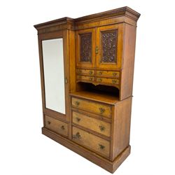 Victorian figured oak and pollard oak combination wardrobe, projecting dentil cornice, the left hand side enclosed by large bevelled mirror glazed door over drawer, the interior with sliding hanging rail, the right hand side with cupboard enclosed by two panelled doors relief carved with urn and trailed trailing foliage, four small drawers over shelf, three drawers and brushing slide, the slide with tooled and gilt blue leather inset, plinth base