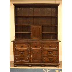  18th century country oak dresser, seven drawers and cupboard with geometric moulding, raised three heights plate rack with cupboard, turned bun feet, W168cm, H221cm, D53cm  