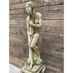 Cast stone garden figure of a bathing lady, raised on square plinth
