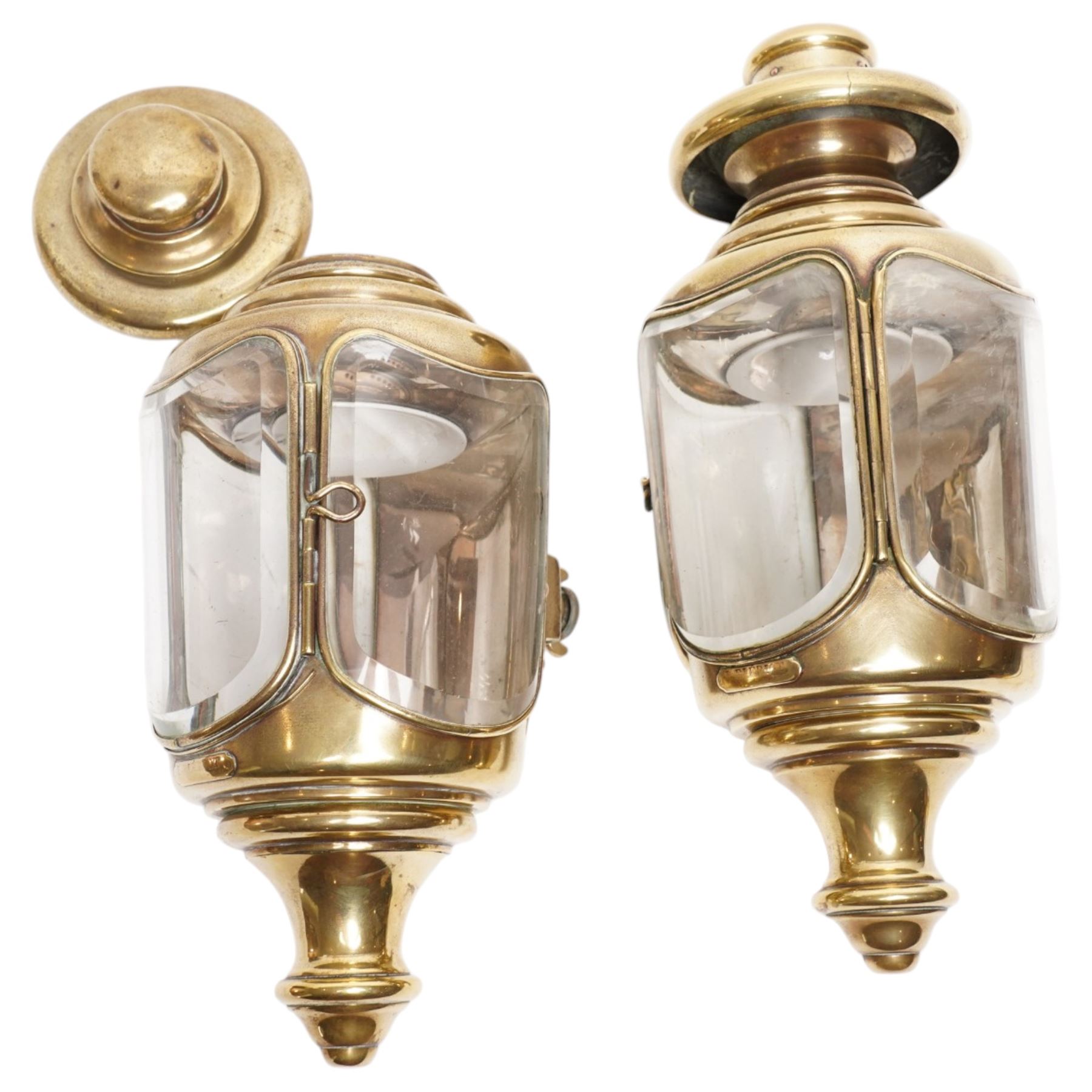 Bleriot Ltd. (London) - pair of Edwardian brass carriage lamps no.152, the body with three faceted bevelled glass panels, surmounted by brass chimney, the back mount with makers plaque below
