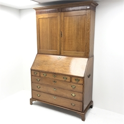 Georgian oak bureau bookcase, projecting cornice, two cupboards above fall front enclosing well fitted interior, six graduating drawers, shaped bracket supports, W135cm, H215cm, D57cm
