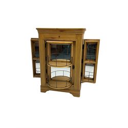 Light oak drinks cabinet, cocktail slide over single revolving door with two side doors that open simultaneously, interior fitted with two large and four small shelves all with mirrored backs