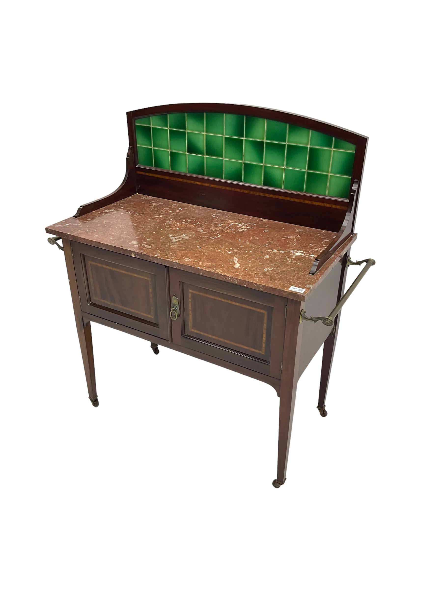 Edwardian inlaid mahogany washstand, raised back with emerald green tiles over marble top, fitted with two panelled cupboard doors, raised on square tapering supports on ceramic castors