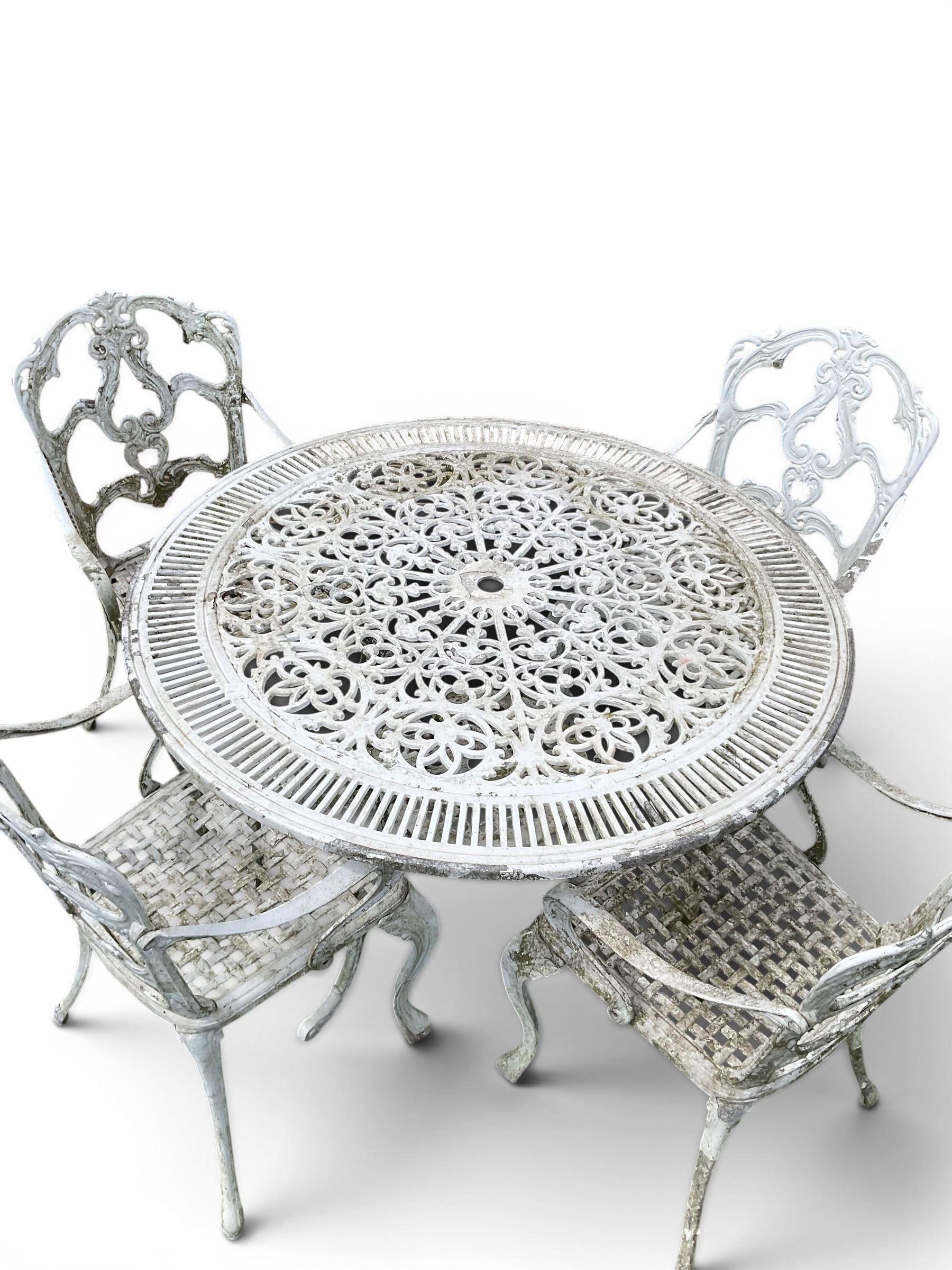 Victorian style cast aluminium white painted garden table and four armchairs chairs with S-scroll acanthus leaf pierced backs over lattice seats