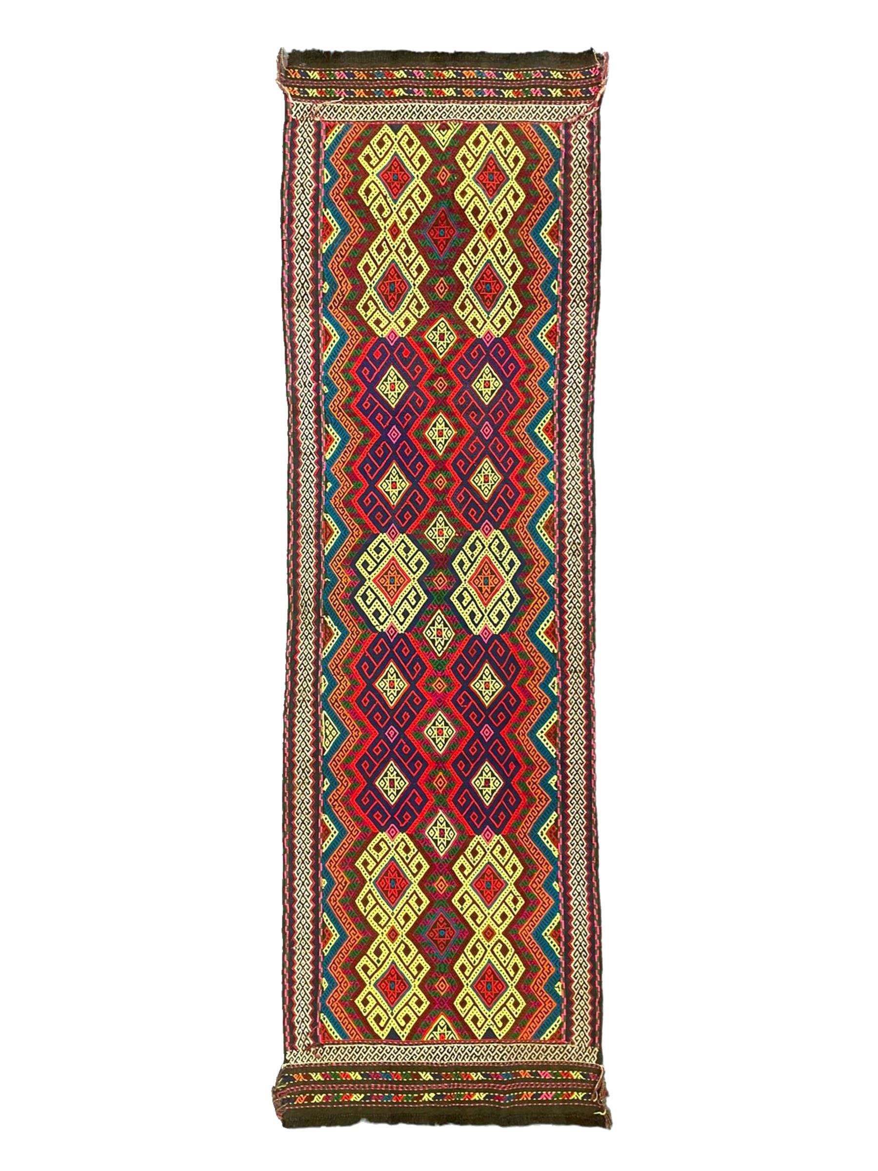 Flatweave geometric design rug, decorated with trailing hooked medallions within zig-zag bands, bright multi-coloured ground 