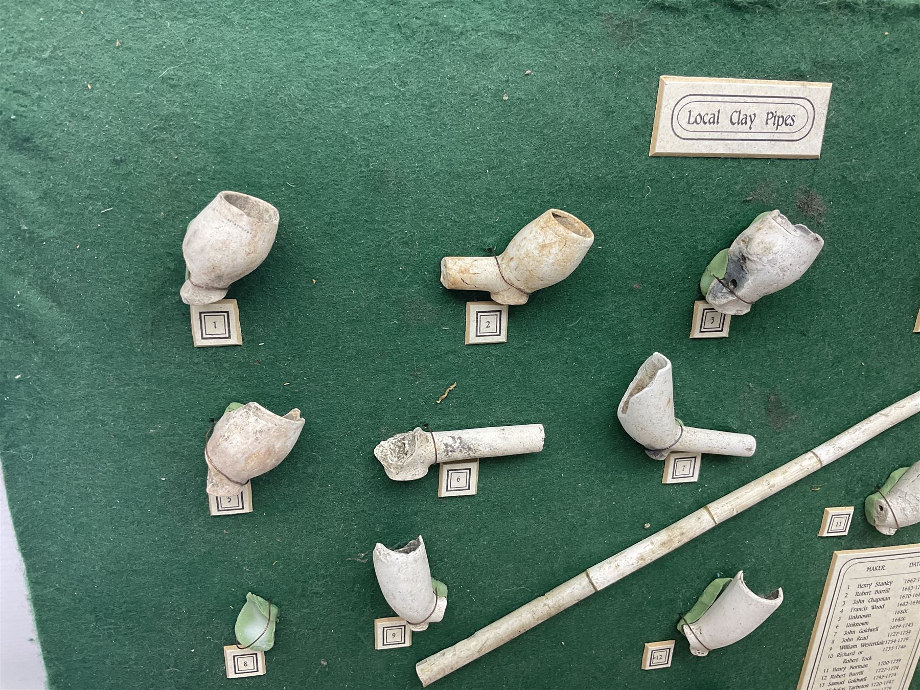 Annotated display board of clay pipes; rootwood walking stick and Yorkshire CCC signed cricket bat 2001
