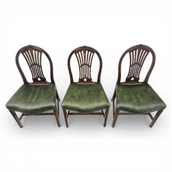 George III style set of six mahogany dining chairs, the arched backs with pierced and carved vase splats beneath carved husk and patera detail, drop-in upholstered seats covered in green leather with brass studded edging, raised on square section legs united by plain stretchers