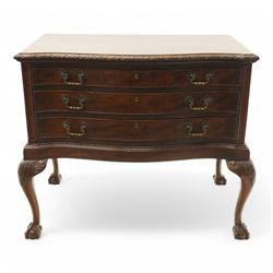 20th century oak and mahogany serpentine chest, the moulded top carved with trailing crossed ribbon and flower heads, fitted with three long cock-beaded drawers, ornate cast gilt metal handles, on acanthus leaf carved cabriole supports with ball and claw feet 