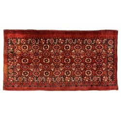 Persian red ground rug, the field decorated with lattice pattern and flowerhead, repeating border decorated with flower heads and leaf motifs