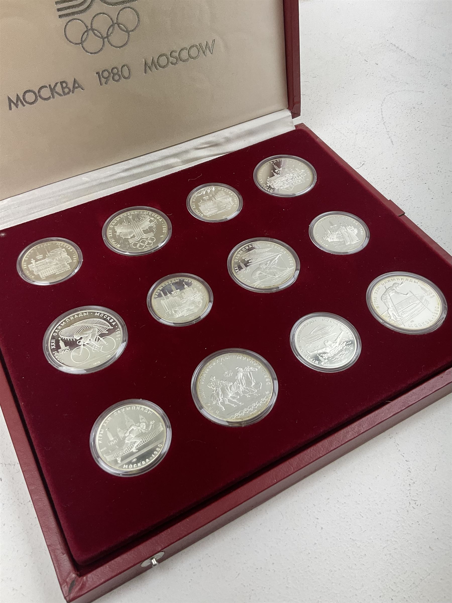 Russian 1980 Moscow Olympic Games silver twenty eight coin set, housed in dated red case and four other coins relating to the Olympics, housed in dated black case