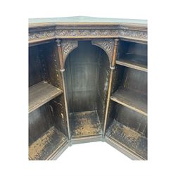 Victorian carved oak corner bookcase, L-shaped form, moulded top over lunette carved frieze, decorated with S-scroll and mask carved corbels with trailing acanthus leaves, fitted with adjustable shelves, on moulded plinth base 